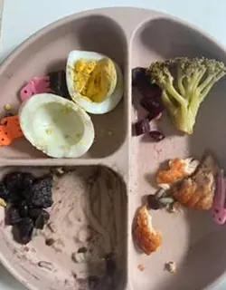 Prato infantil do almoço, com a maior parte da comida já comida